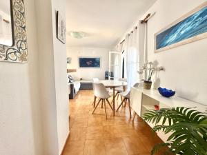 a hallway with a table and chairs in a room at White Sands 4.20 in Arenal d'en Castell