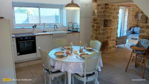 a dining room with a table and chairs and a kitchen at Ty Penty in Riantec