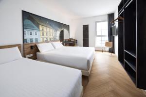 a hotel room with two beds and a tv at B&B Hotel Maribor in Maribor +24 photos
