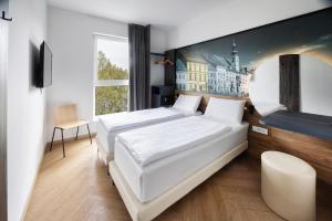 a bedroom with two beds and a painting on the wall at B&B Hotel Maribor in Maribor