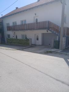 a large white house with a garage and a balcony at Luce in Tomislavgrad +4 photos
