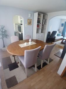 a dining room with a wooden table and white chairs at Luce in Tomislavgrad