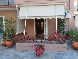 a patio with a table and chairs and plants at Nini's House 1 Nydri - 100m from beach NYDRI TOWN CENTER in Nydri