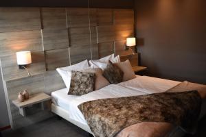 a bedroom with a large bed with a wooden wall at Hotel De Vrouwe van Stavoren in Stavoren