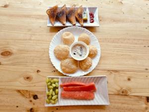 a table with a plate of food with bread and fruit at White Forest - PV Hotels in Pondicherry