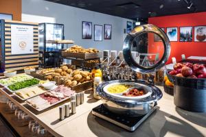 a buffet with different types of food on a table at B&B Hotel Maribor in Maribor
