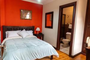 a red bedroom with a bed and a bathroom at La POSADA CUENCANA EN CUENCA in Cuenca +39 photos