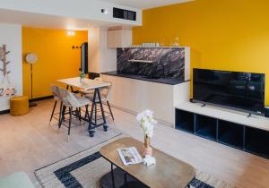 a living room with a large television and a table at Cowool Créteil in Créteil