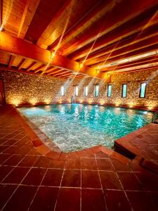 ein großes Schwimmbecken in einem Gebäude mit Beleuchtung in der Unterkunft Hotel Kulla e Arte in Razëm