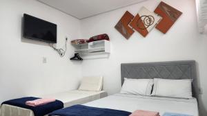 a room with two beds and a tv on the wall at Casa requinte estilo Ap próx Fema Unesp in Assis