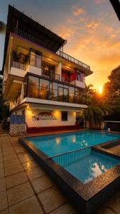 a building with a swimming pool in front of a building at Colors Fly Hotel in Colva +13 photos