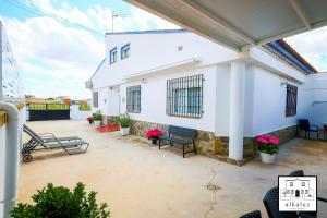 a patio with two benches and a white building at Chalet Rural Alkaluz in Las Eras +45 photos