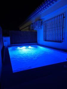 a swimming pool with blue lighting in the dark at Chalet Rural Alkaluz in Las Eras