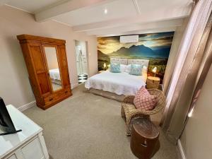 a bedroom with a bed and a painting on the wall at Mont d'Or Franschhoek in Franschhoek