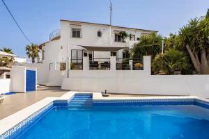 a house with a swimming pool in front of a house at Villa Amare in Benissa