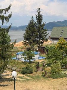 a house with a swimming pool in front of a lake at Dedinski Raj in Golubac