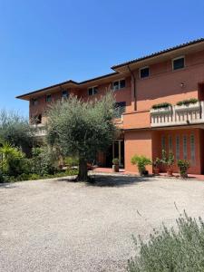 a building with a tree in front of it at La Corte delle Marche in Osimo