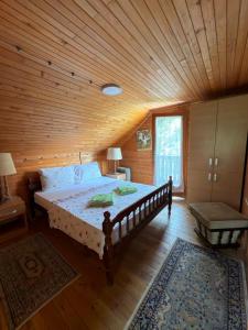 a bedroom with a large bed in a wooden room at Dedinski Raj in Golubac +11 photos