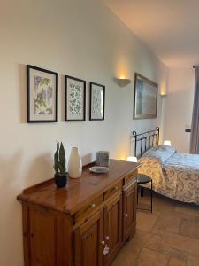 a bedroom with a wooden dresser and a bed at La Corte delle Marche in Osimo