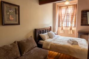 a bedroom with a bed and a couch at La POSADA CUENCANA EN CUENCA in Cuenca