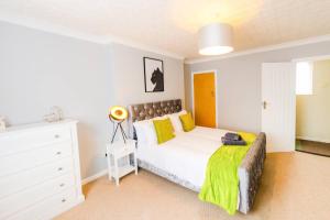 a bedroom with a white bed and a white dresser at 4 Bed - 2 Baths 1 Walk in Shower Lots of Parking in Ipswich