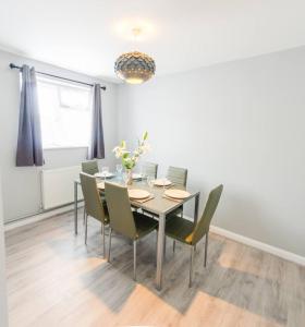 a dining room with a table and chairs at 4 Bed - 2 Baths 1 Walk in Shower Lots of Parking in Ipswich