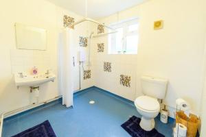 a bathroom with a toilet and a sink at 4 Bed - 2 Baths 1 Walk in Shower Lots of Parking in Ipswich +1 photo