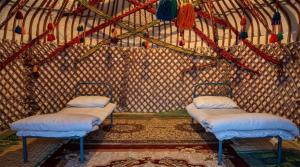 a room with two beds in a yurt at Хостел18А in Nukus