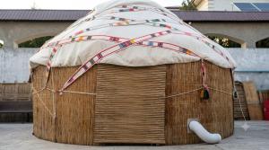 a dog house with an umbrella on top of it at Хостел18А in Nukus