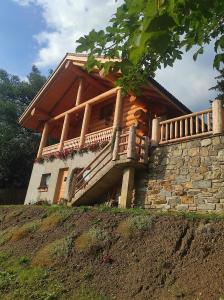 a house with a balcony on top of a hill at Rustic House in Predeal