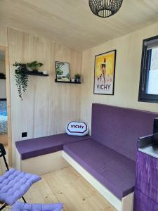 a purple bench in a room with a purple couch at La tiny de Miss Purple in Chantelle
