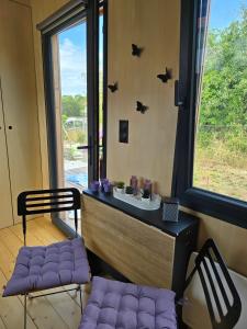 a room with two chairs and a window with bats on the wall at La tiny de Miss Purple in Chantelle