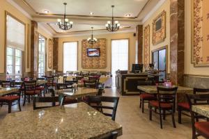a restaurant with tables and chairs and a lobby at Hotel Victoria Merida in Mérida