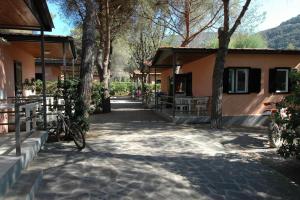 a building with trees next to a walk way at Villaggio Turistico Sole e Mare in Nisporto