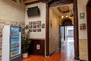 a room with a refrigerator and a television on the wall at La POSADA CUENCANA EN CUENCA in Cuenca