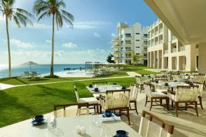 a patio with tables and chairs and a view of the ocean at The Residences at The St. Regis Bermuda in Saint George