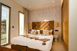 a bedroom with a large white bed and a window at Luxurious Marrakech Villa Pool, Hammam,Cinema in Marrakesh +9 photos