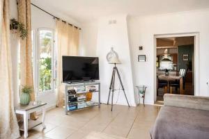 a living room with a flat screen tv and a table at Villa Amare in Benissa
