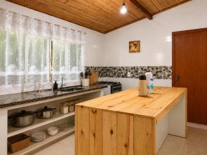a kitchen with a wooden island in the middle at Casa com Vista inigualável "Vista del Lago" in Capitólio