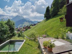 a house with a swimming pool on the side of a hill at Chalet Sonnenheim, Wohnung mit Panoramafenster in Adelboden
