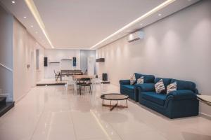 a living room with a blue couch and a table at فيلا تولاي in Dahaban