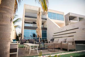 a building with a patio with chairs and an umbrella at فيلا تولاي in Dahaban
