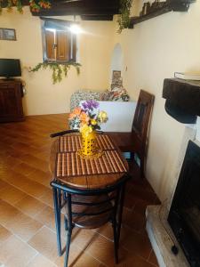a room with a table with a vase of flowers on it at Lo Chalet del Borgo in Rivisondoli