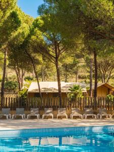 a group of chairs sitting next to a swimming pool at wecamp L'Escala Punta Milà in L'Escala