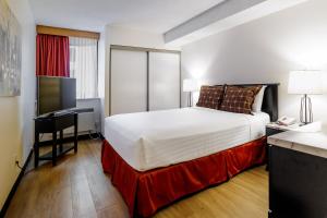 a hotel room with a large bed and a desk at Cartier Place Suite Hotel in Ottawa +52 photos