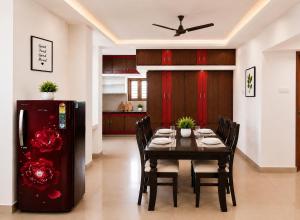 a dining room with a table and a refrigerator at SLS Homestay - Luxury AC Service Apartments 1BHK, 2BHK, 3BHK - Direct Flyover to Alipiri Tirumala Gate - Walk to PS4 Pure Veg Restaurants, Supermarkets - Near to National Highway & Padmavathi Amma Temple - Modular Kitchen, Living room -Free Superfast Wifi in Tirupati