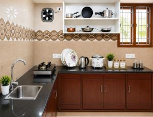 a kitchen with a sink and a counter top at SLS Homestay - Luxury AC Service Apartments 1BHK, 2BHK, 3BHK - Direct Flyover to Alipiri Tirumala Gate - Walk to PS4 Pure Veg Restaurants, Supermarkets - Near to National Highway & Padmavathi Amma Temple - Modular Kitchen, Living room -Free Superfast Wifi in Tirupati