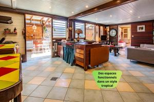 a room with a kitchen and a living room at Jaden Kreyol - Gîte central, spa, piscine, BBQ in Lamentin