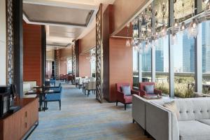 a waiting room with chairs and tables and windows at Sheraton Beijing Lize Hotel in Beijing