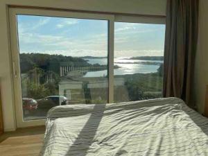 a bedroom with a bed and a large window at Seaside panorama Villa with JETLESS hot tub in Gothenburg
